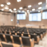 Seminar conference or town hall meeting blur background in auditorium or hotel room with audiences, speaker podium stage and presentation screen for entrepreneurship business speech or community talk