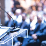 Public speaker at business conference, corporate presentation, workshop, coaching training, news conference, company meeting, public or political event